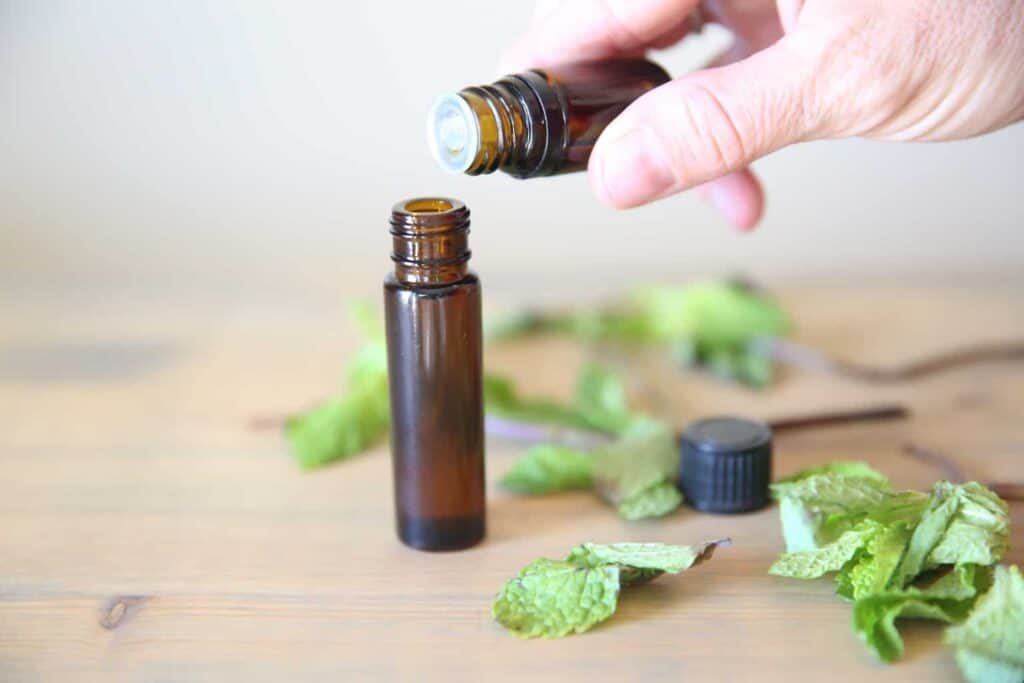 Adding pure peppermint essential oil to a roller bottle.