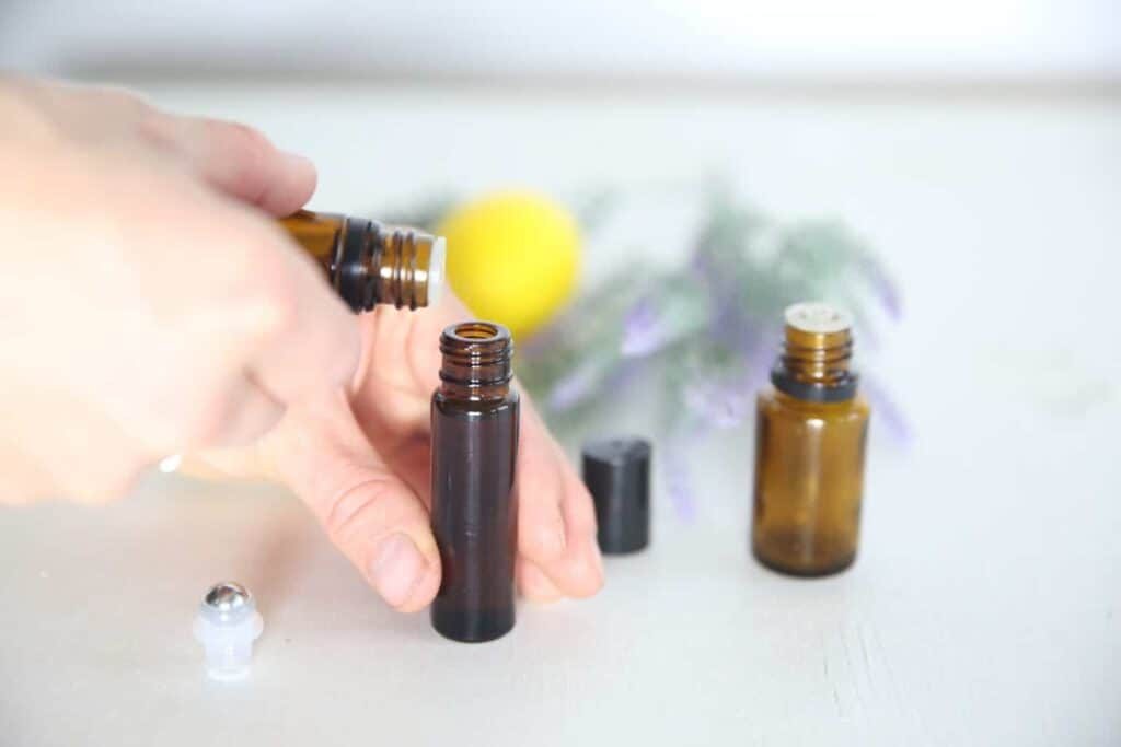 A woman making a lemon lavender and peppermint roller bottle.