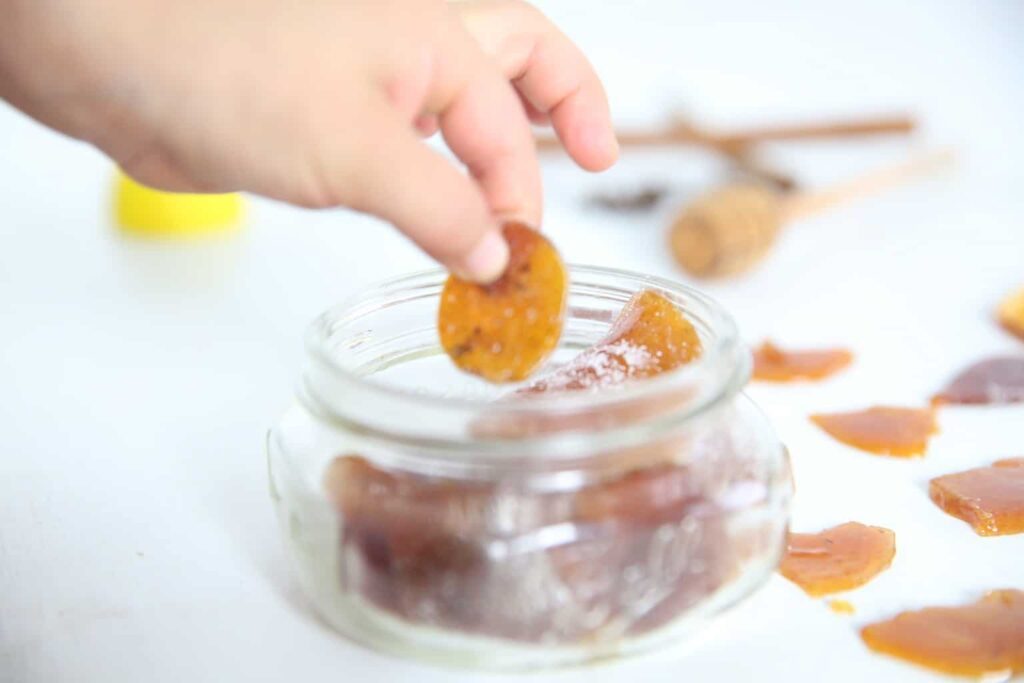 Removing cough drop from small mason jar.