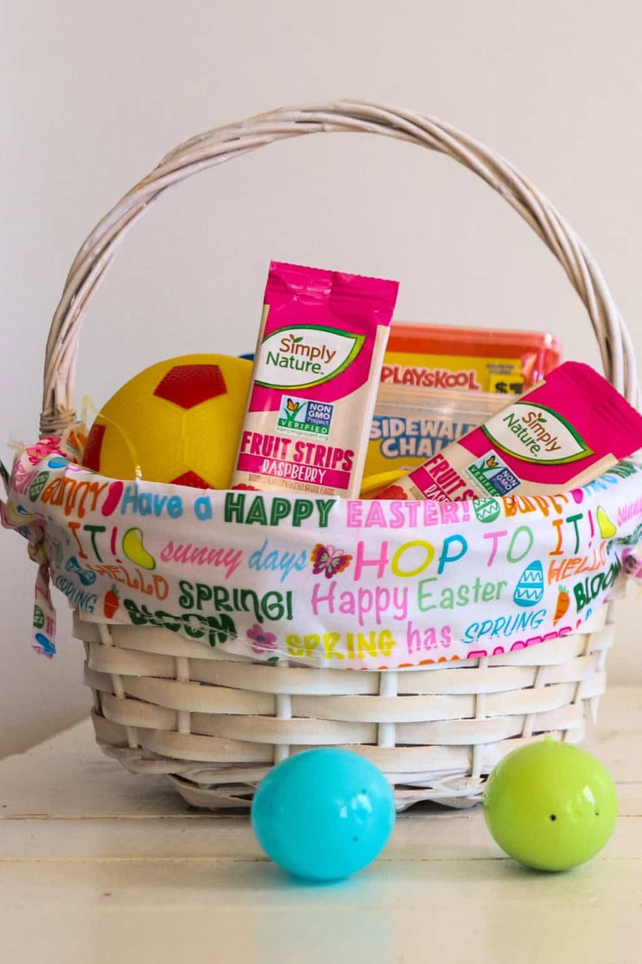 An Easter basket filled with non-candy treats and two plastic Easter eggs.