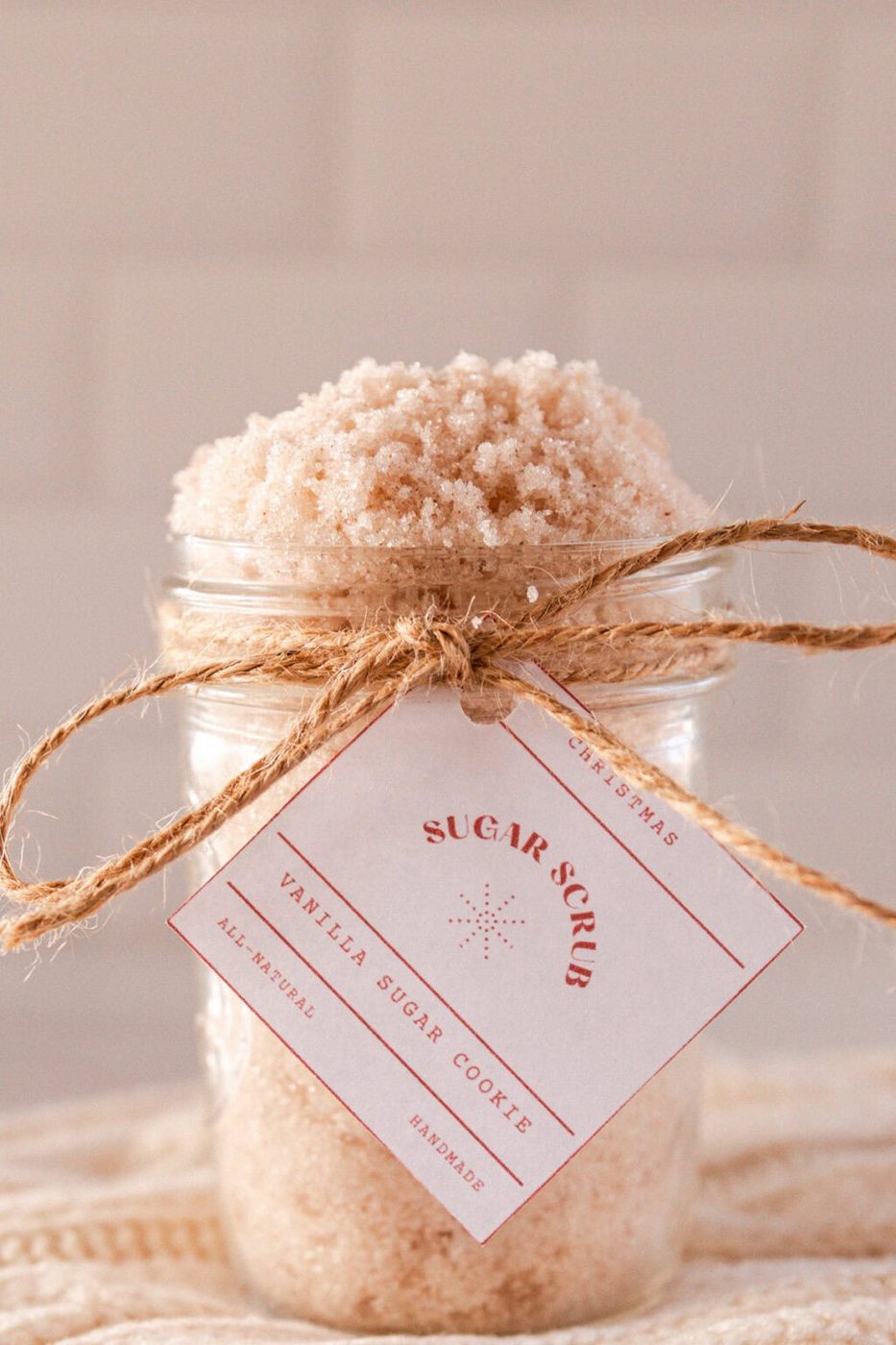 A jar of sugar cookie scrub with a label tied on with twine.