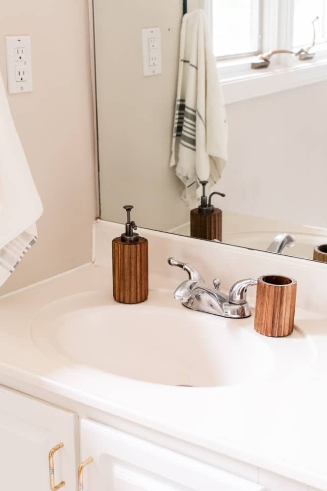 A bathroom sink, mirror, towel and faucet.