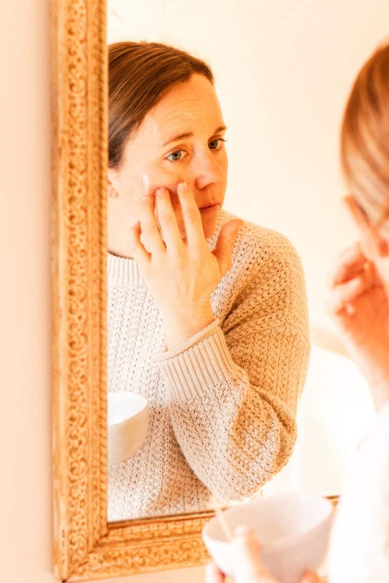 Wiping on the baking soda face mask with our fingers.