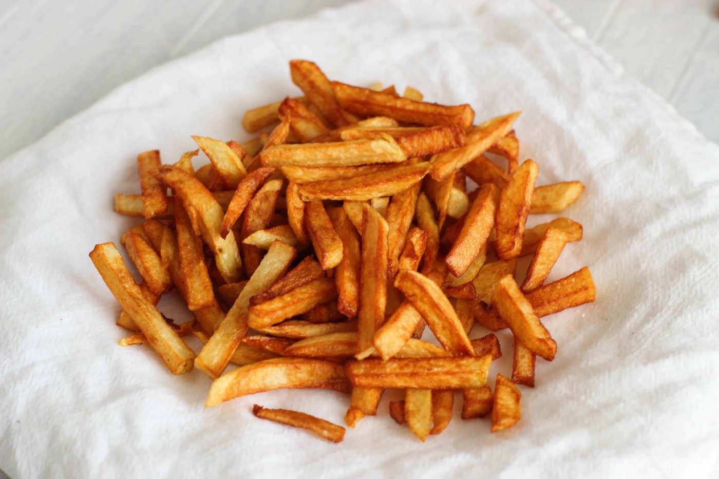Crispy French fries on white towel.