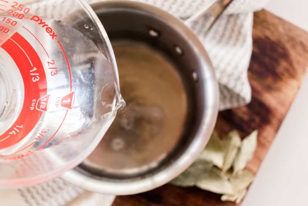 Adding hot water to bay leaves.