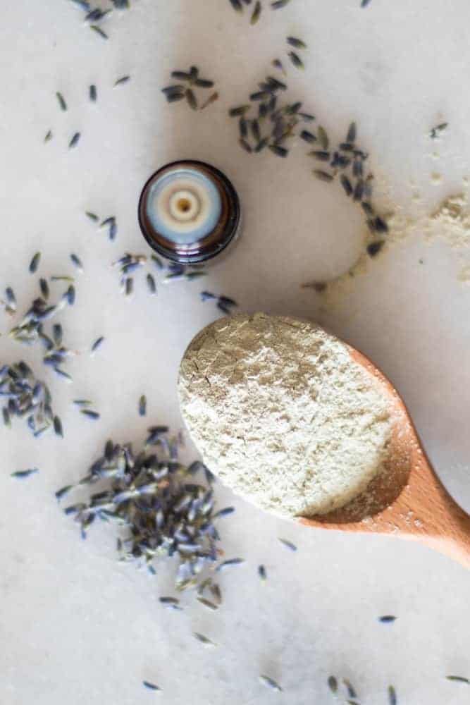 powder clay on wooden spoon with lavender springs around it