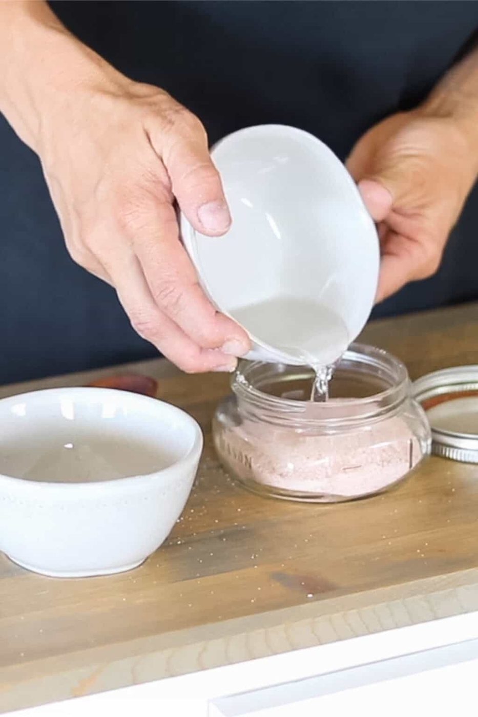 Pouring the fractionated coconut oil onto the pink salt.