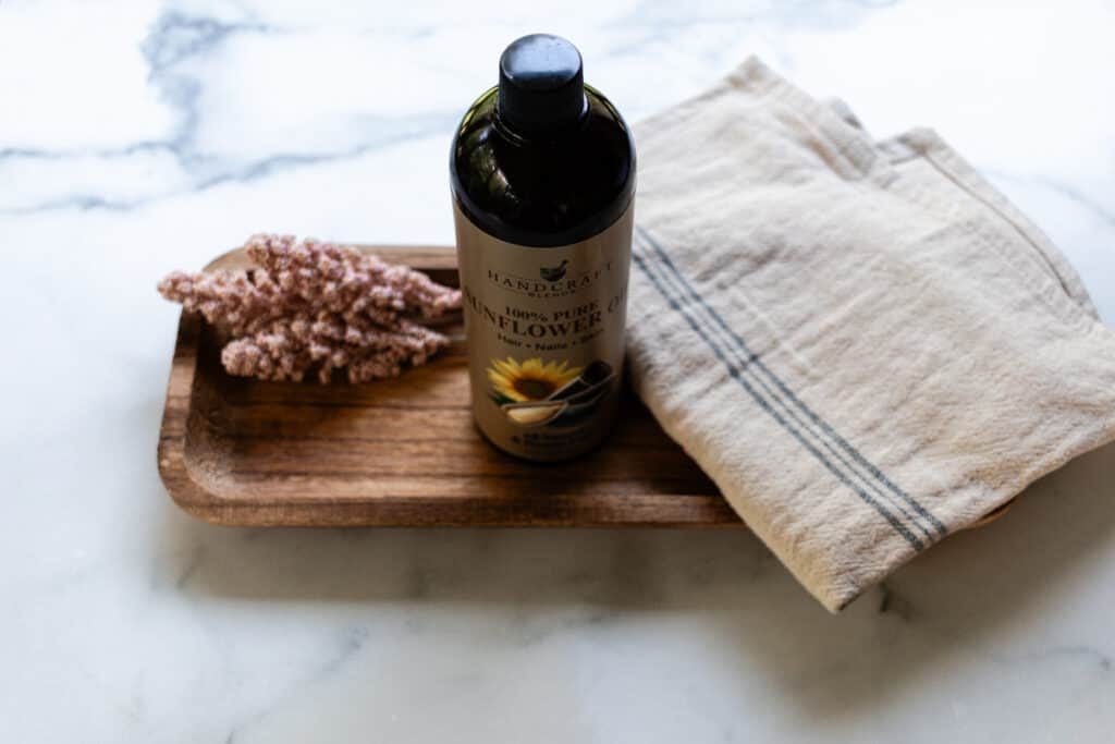 Sunflower oil with a decorative towel on white marble.