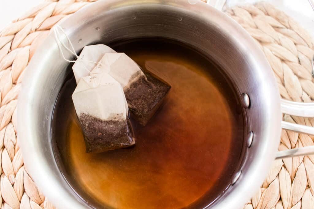 Stewing black tea teabags in water.