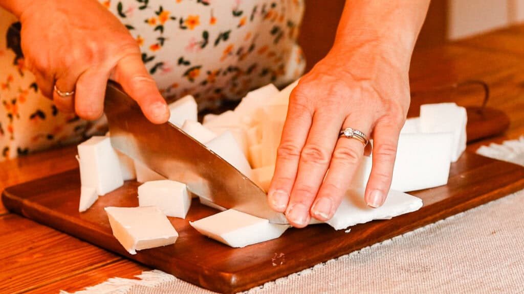 Cutting a melt and pour soap base into smaller pieces with a chopping knife.