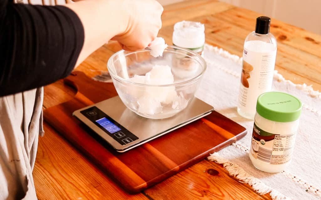 Measuring out the coconut oil that is going to be used in the soap using a digital calculator.