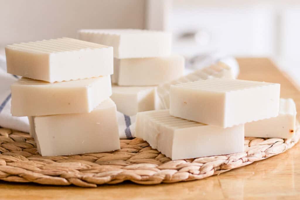 Stacks of cold process shampoo bars on a wicker placemat.