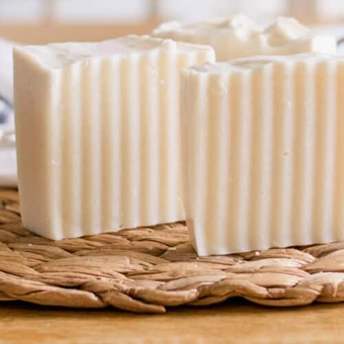 Two cold process shampoo bars standing upright on a wicker mat.