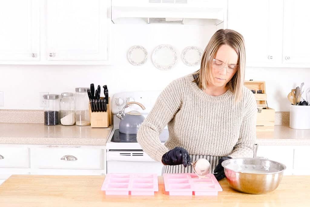 Scooping soap mixture into a silicone soap mold.