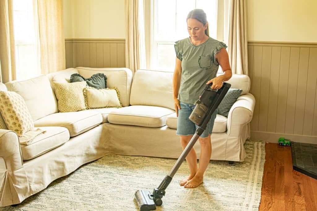 Vacuuming a living room rug.
