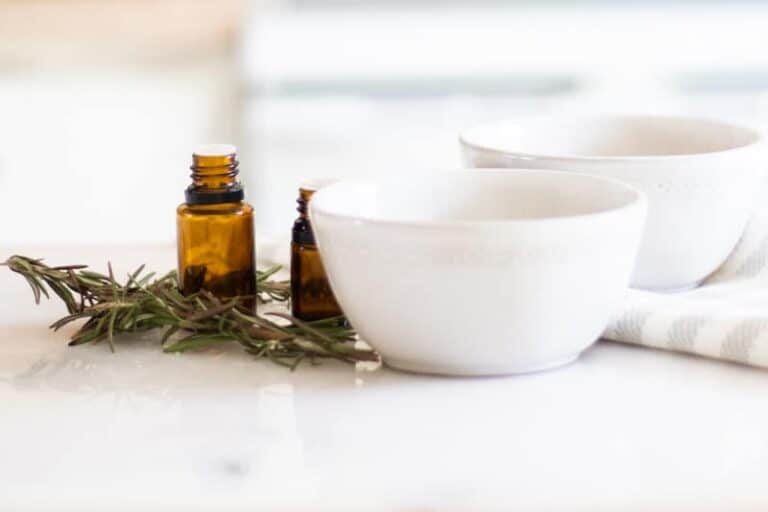 white bowls with fresh rosemary on marble table sitting on a white and grey towel