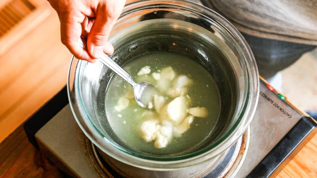 Stirring the mixture in the double boiler as it melts together.