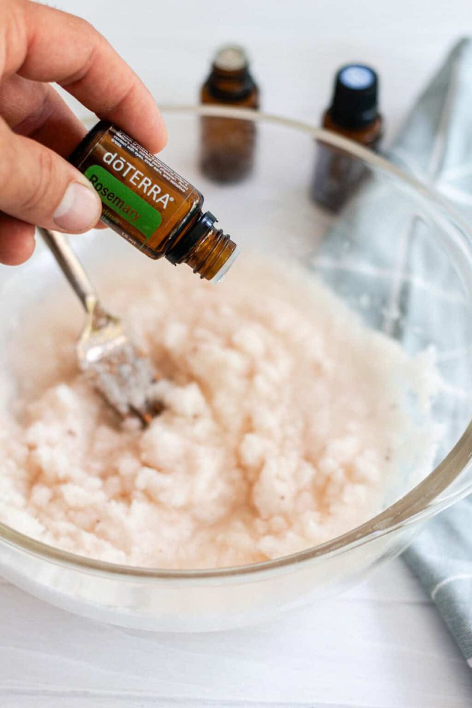 Adding essential oils for the foot bath mixture in a glass bowl.