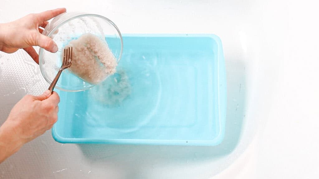 Pouring the foot bath salt mixture into a basin with water for a foot bath.
