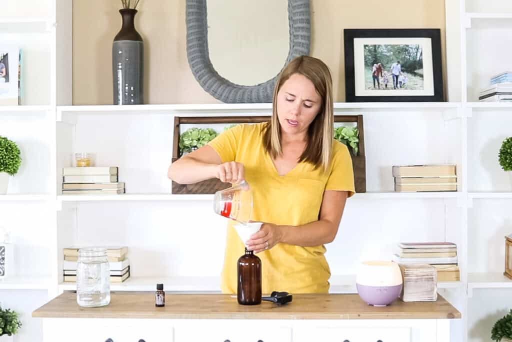 Pouring water into a spray bottle.