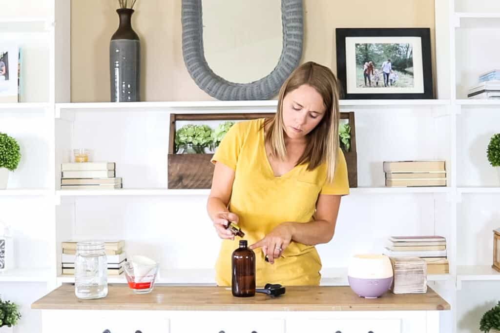 Adding essential oils to a spray bottle.
