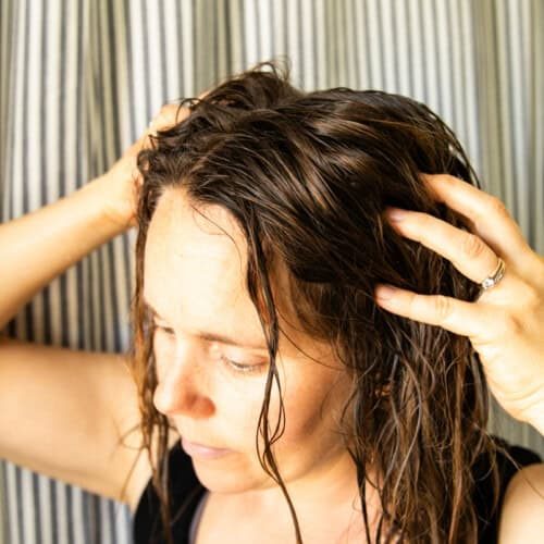 Massaging baking soda hair rinse into the hair.