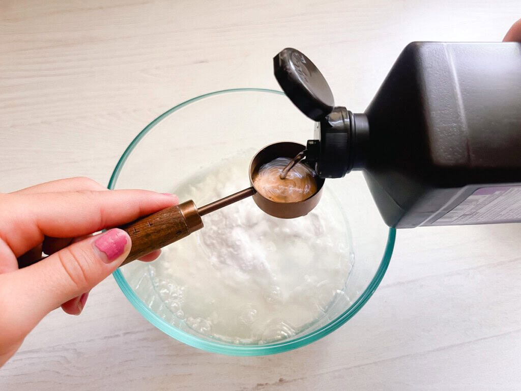 Pouring hydrogen peroxide in a bowl of baking soda.
