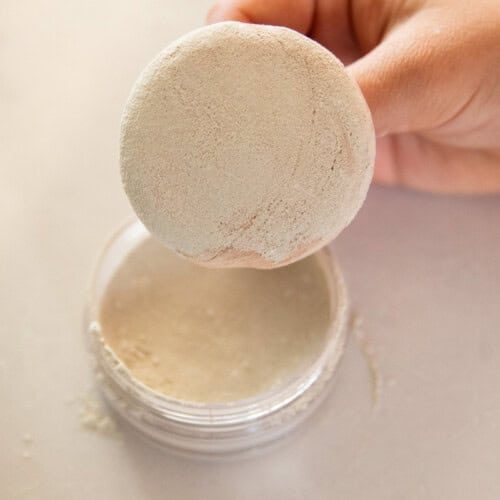 DIY body powder in a jar with a powder puff.