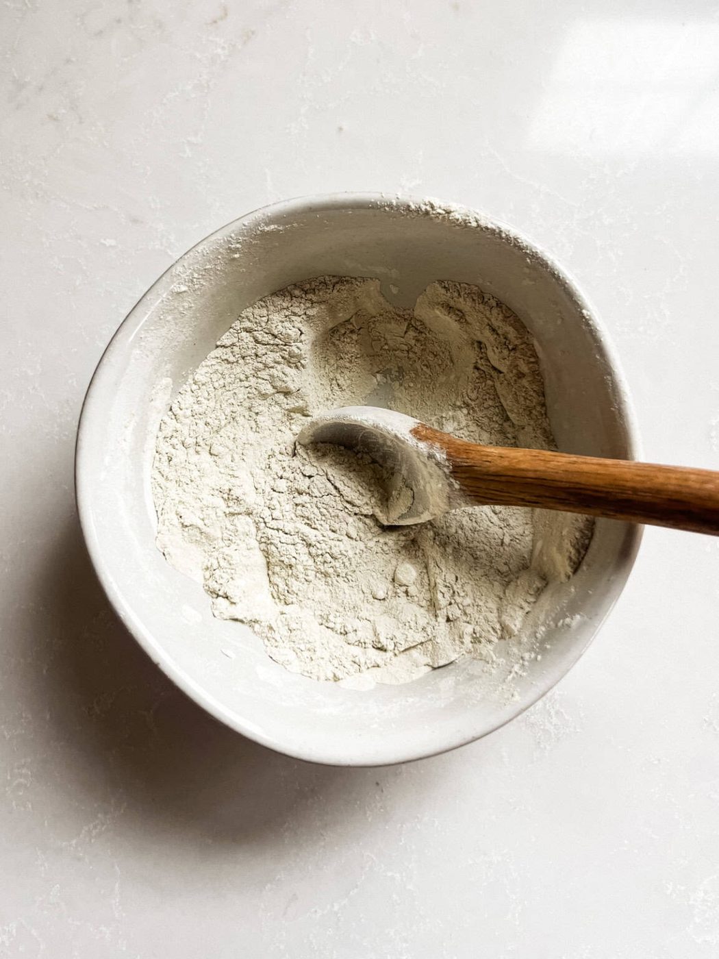 Stirring ingredients together in a small mixing bowl to make body powder.