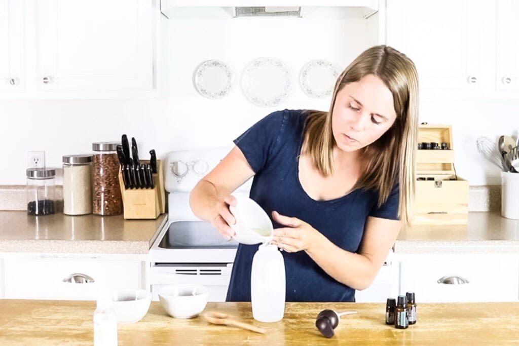 Pouring vegetable glycerin and castile soap into a foaming soap bottle.