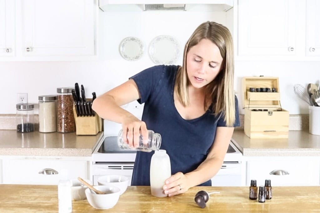 Pouring water into a foaming soap bottle to make natural body wash.