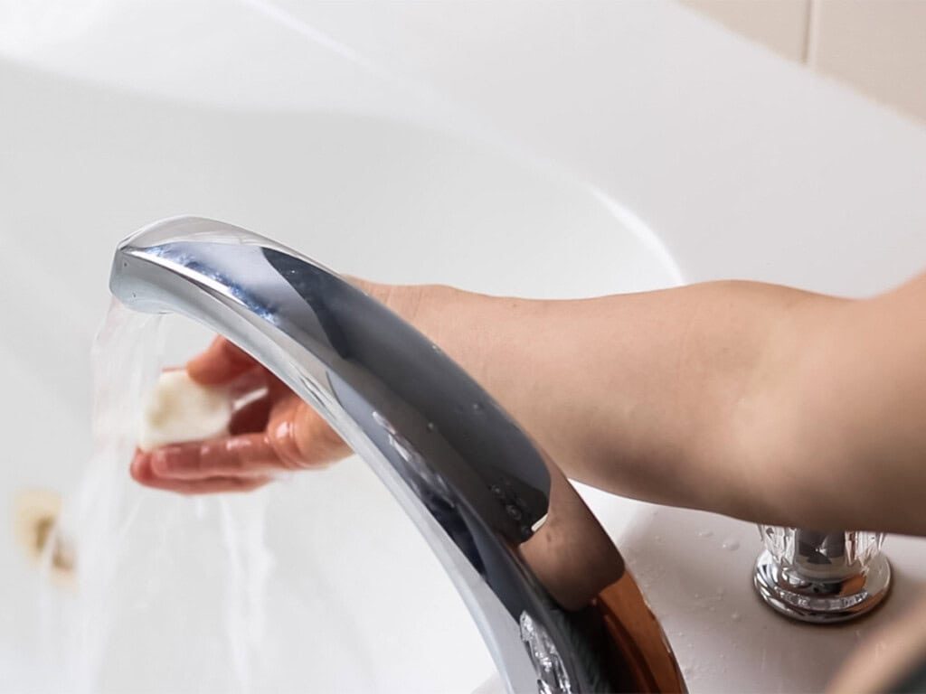 Running warm water over a bubble bath bar.