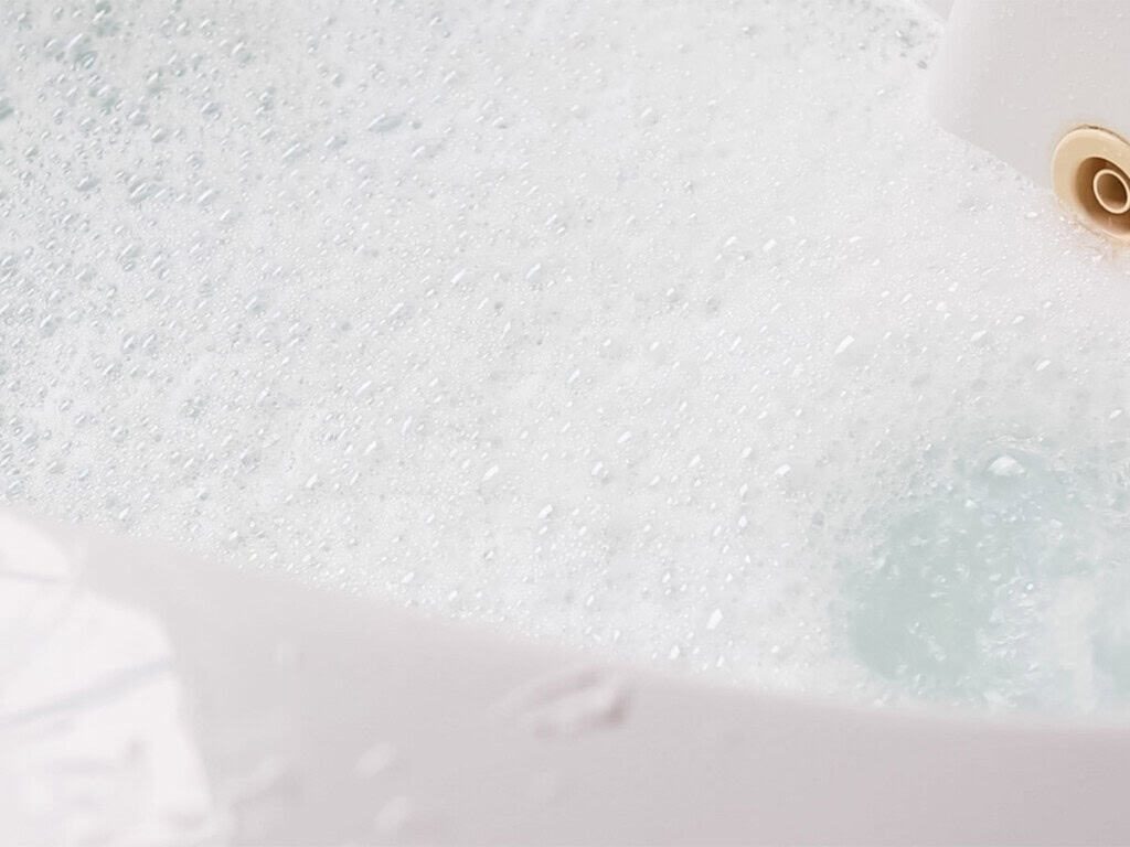 A bathtub filled with soapy bubble bath water.