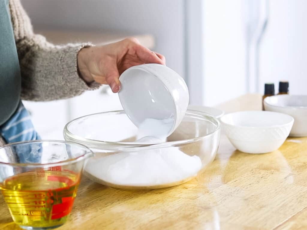 Pouring dry ingredients into a glass bowl.