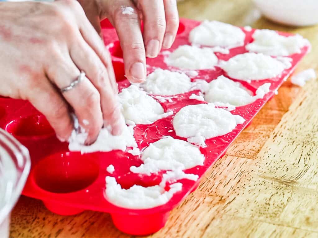 Packing bubble bath bar mixture into silicone molds.