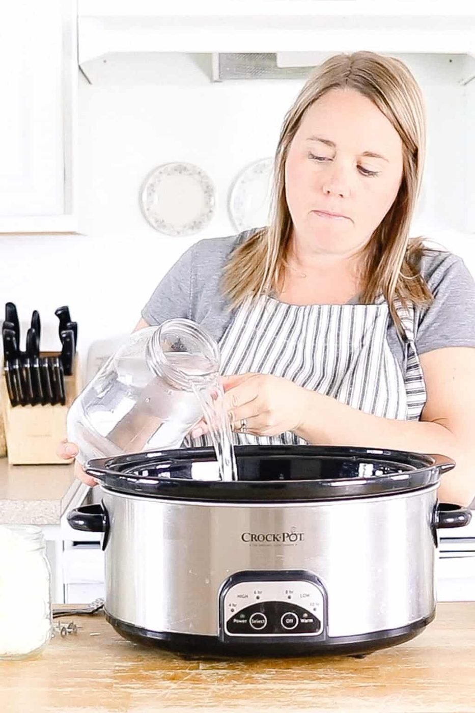 Pouring water into a crockpot.