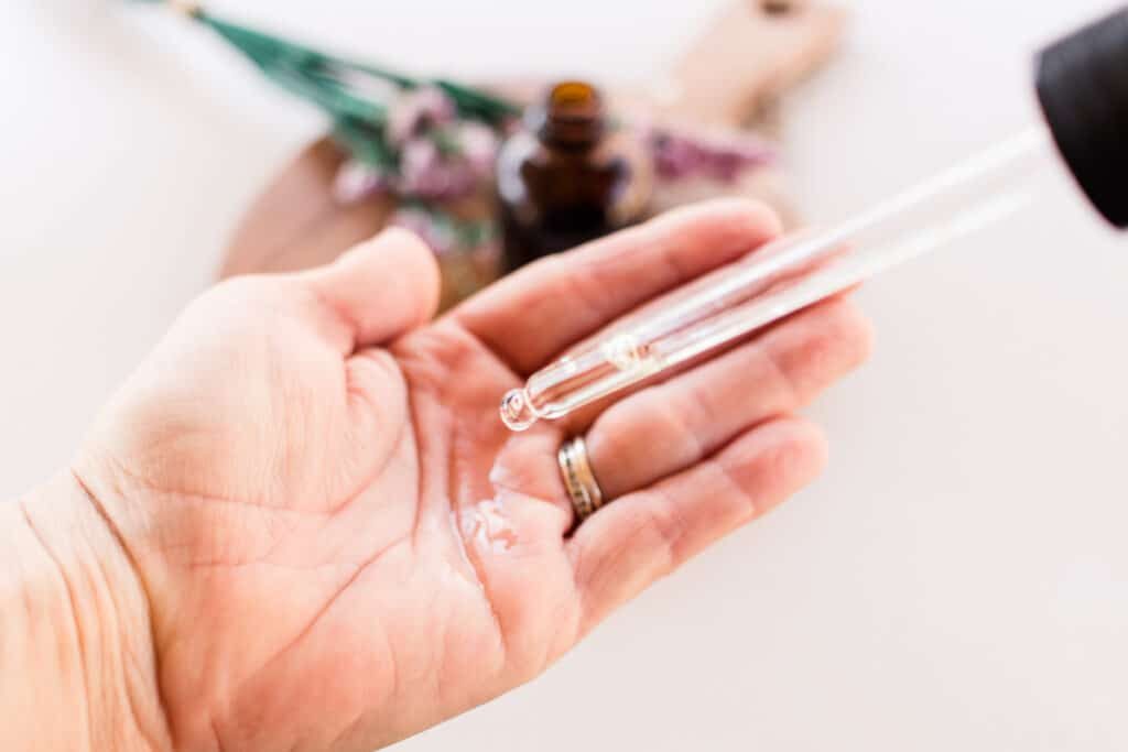 Applying a few drops of the cleansing oil to the palm of our hand.