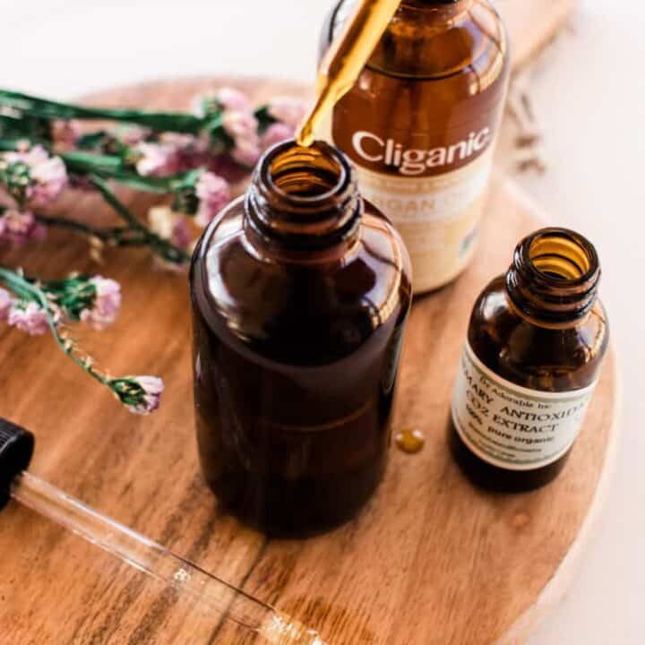 Using a dropper to add oil to a cleanser bottle.
