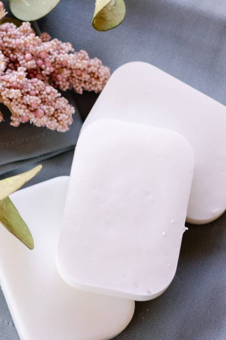 Cold process coconut oil soap bars arranged on a blue tea towel before use.