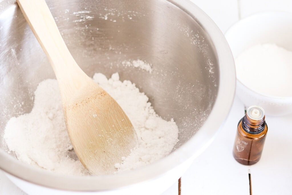 Stirring the dried ingredients for the dishwasher soap tabs in a large mixing bowl.