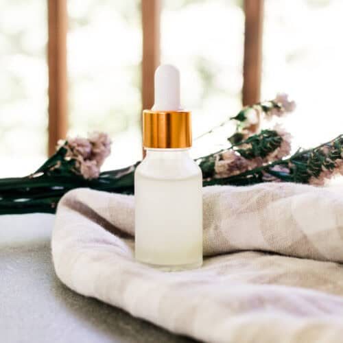 A bottle of eye serum on a checkered linen.
