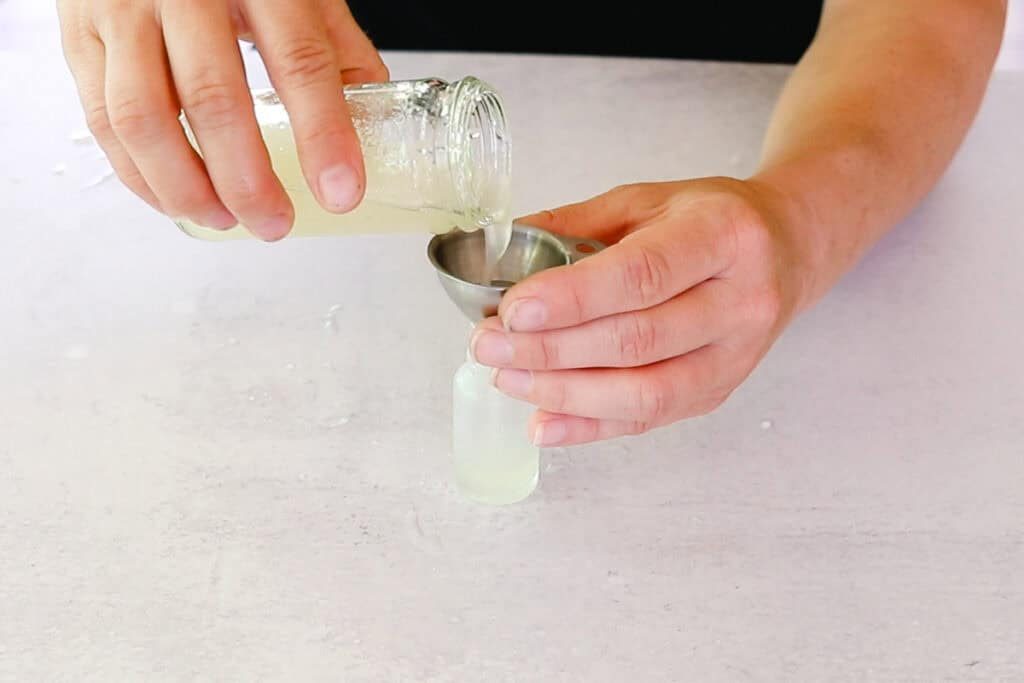 Pouring the eye serum into a dropper bottle.