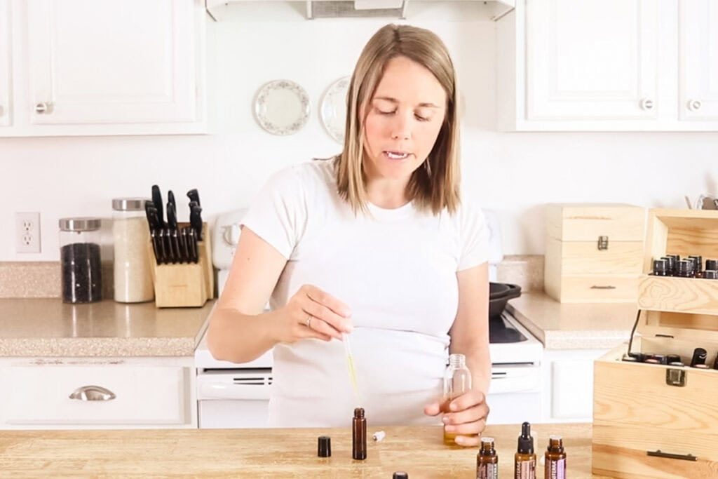 Using a small squeeze funnel to fill the the roller bottle with a carrier oil.