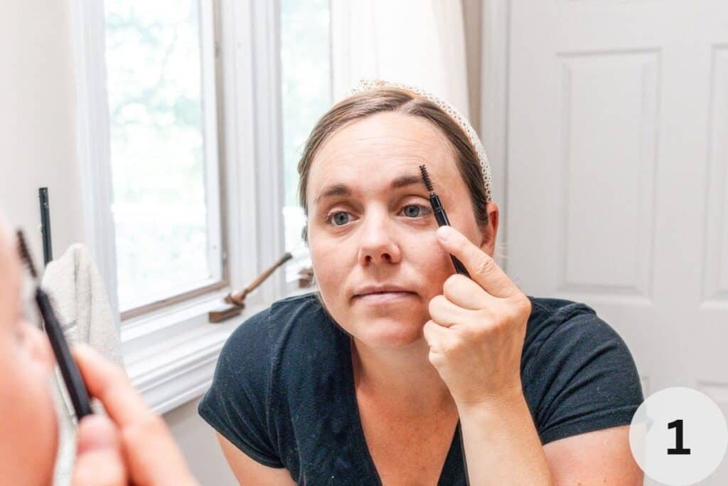 Brushing eyebrows with a small brow brush.