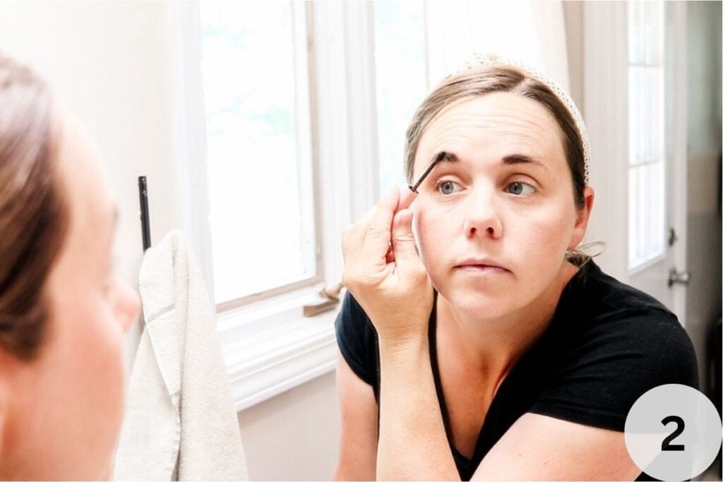 Applying the eyebrow tint to our eyebrows with an applicator brush.