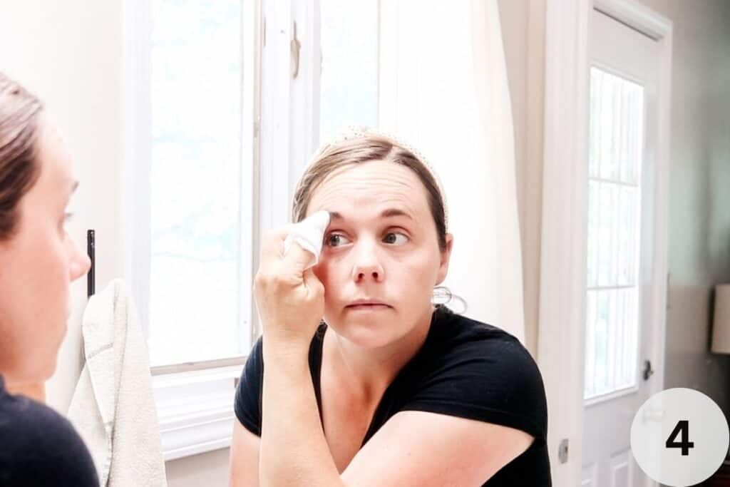Wiping the DIY eyebrow tint off with a rag.