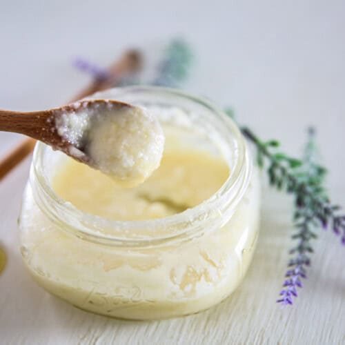 Scooping a spoonful of homemade face wash out of a jar.