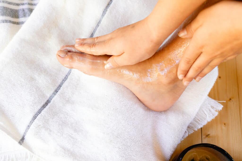 Rubbing the foot mask all over, even the tops of the feet.