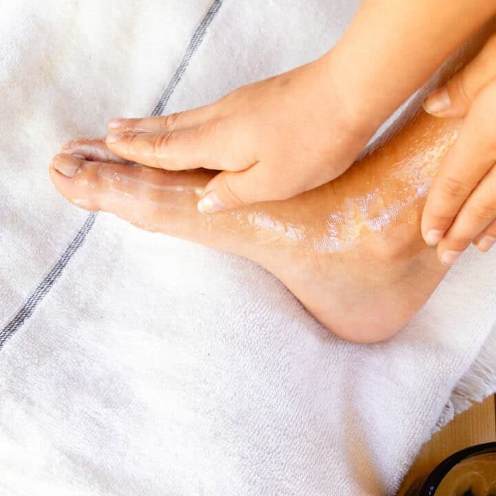 Rubbing a hydrating foot mask onto our feet while they rest on a towel.