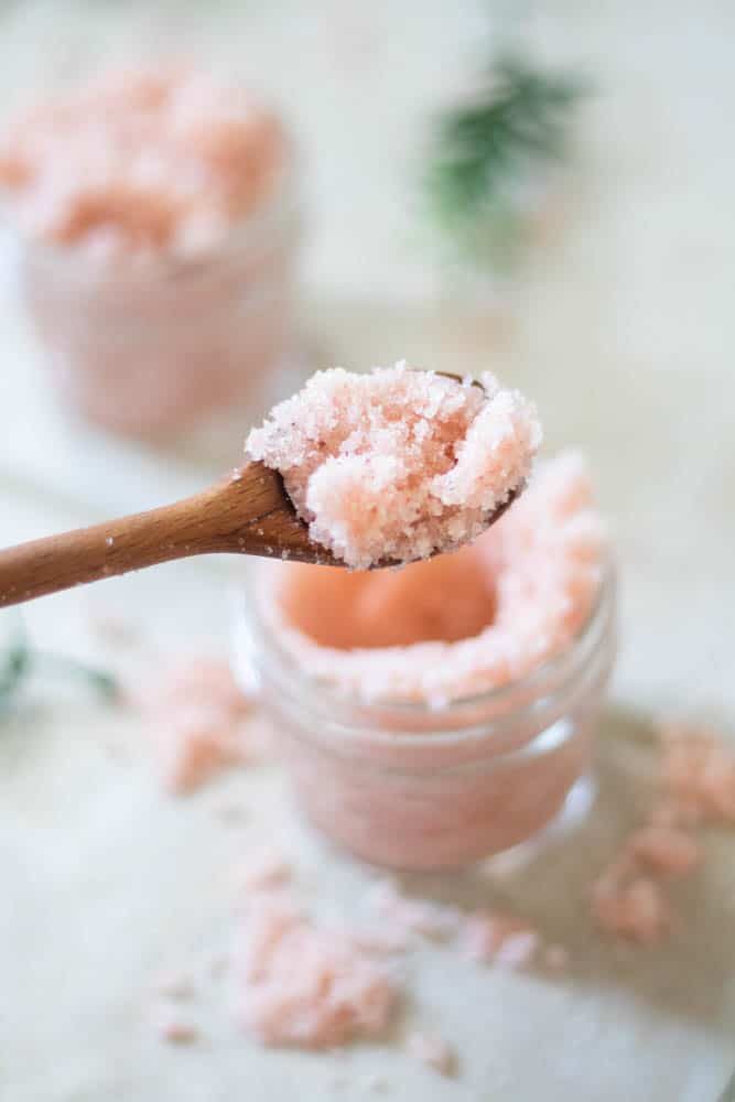 Pink Himalayan homemade foot scrub for cracked skin on the end of a wooden applicator.